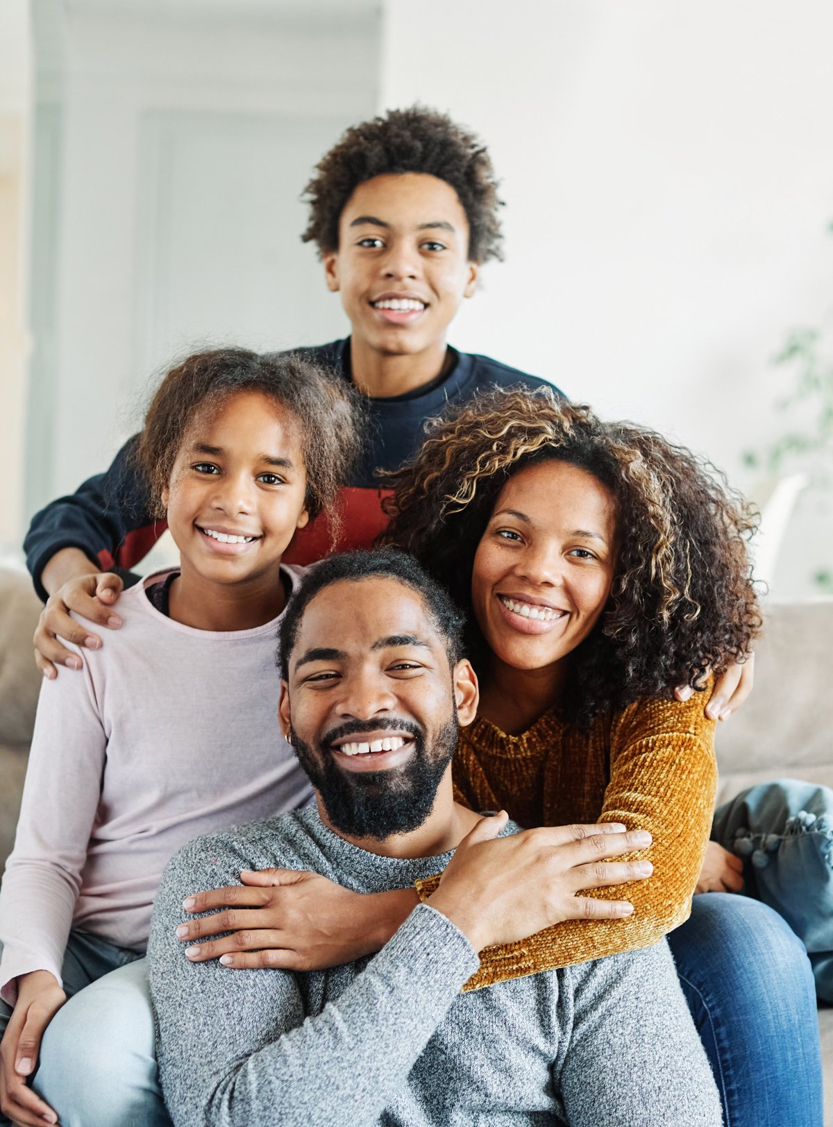 A happy Black family sitting together on the couch at home